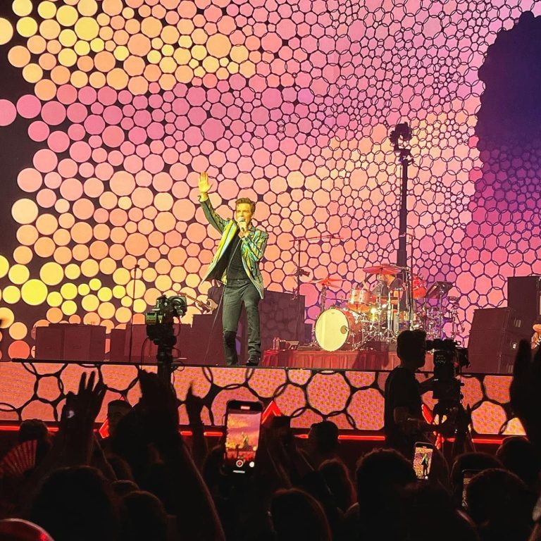 Bild från konsert med The Killers i Glasgow. Sångaren Brandon Flowers vinkar till publiken. 